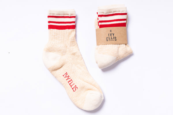 Pair of cream socks with red and white stripes on a white background
