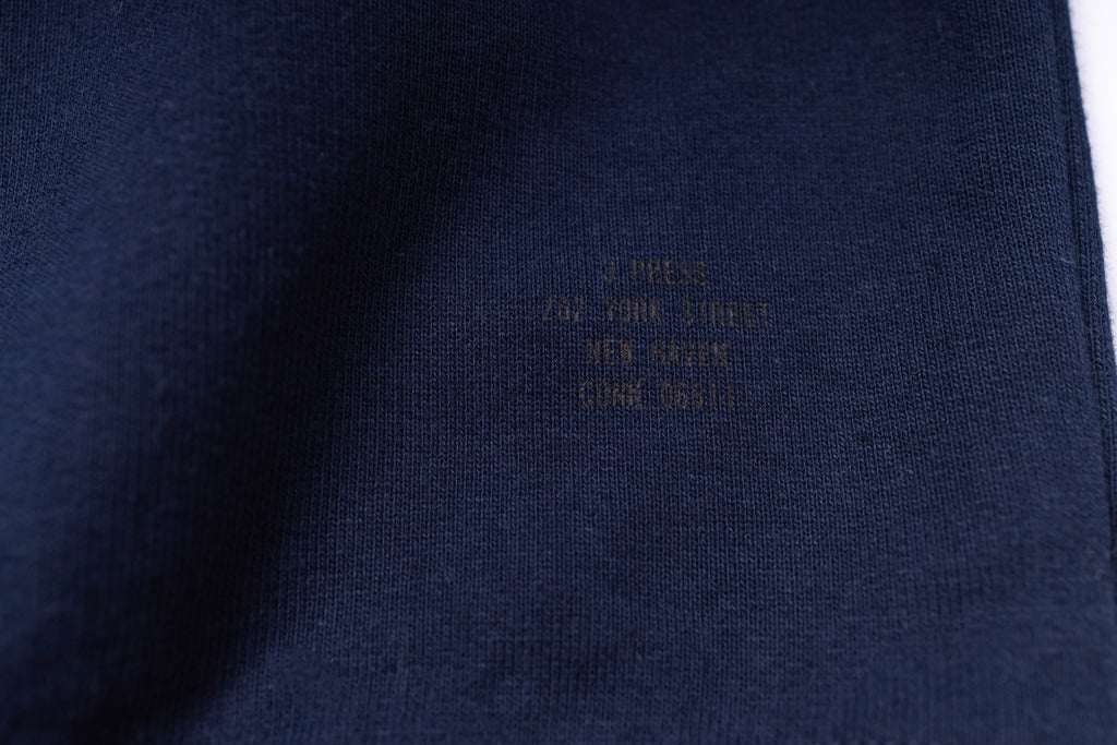 Close-up of a navy blue fabric with embroidered text on a white background