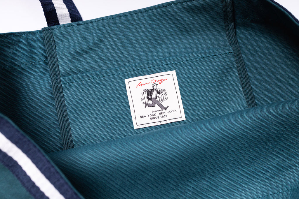 Teal tote bag with a brand label on a white background