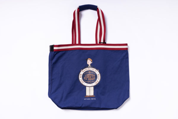 Blue tote bag with red and white striped handles on a white background
