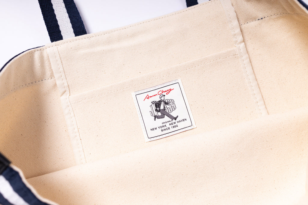 Close-up of a beige bag with a brand label on a white background