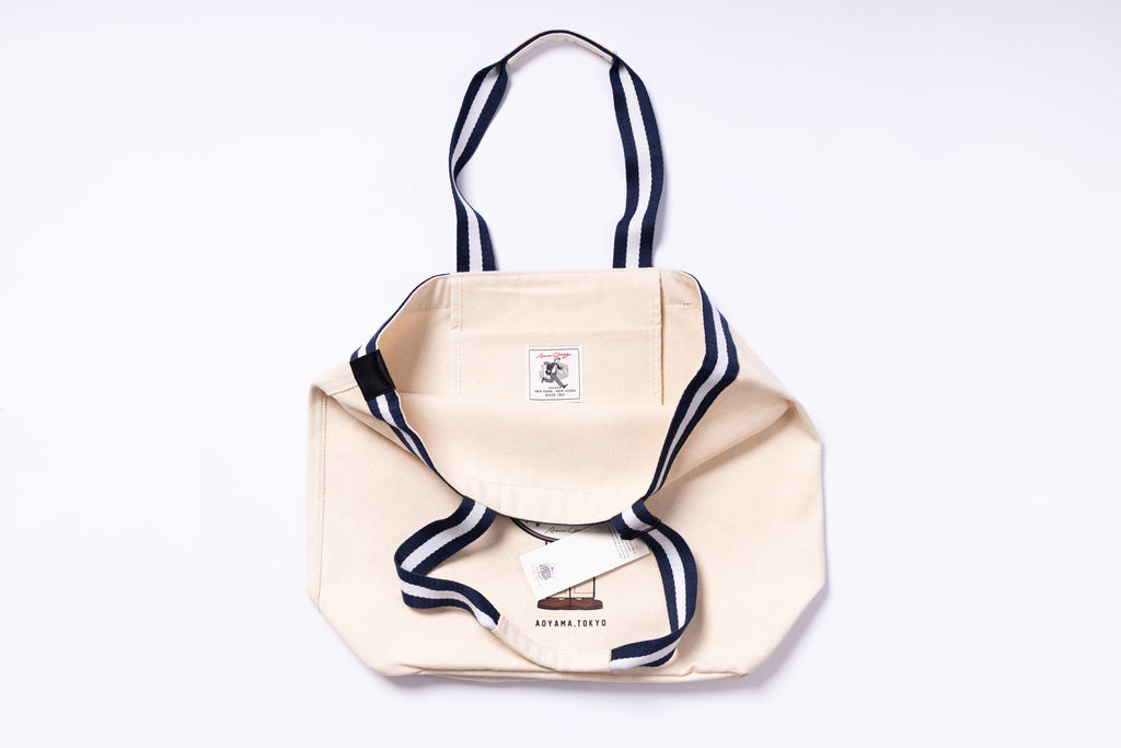 Beige tote bag with navy accents on a white background