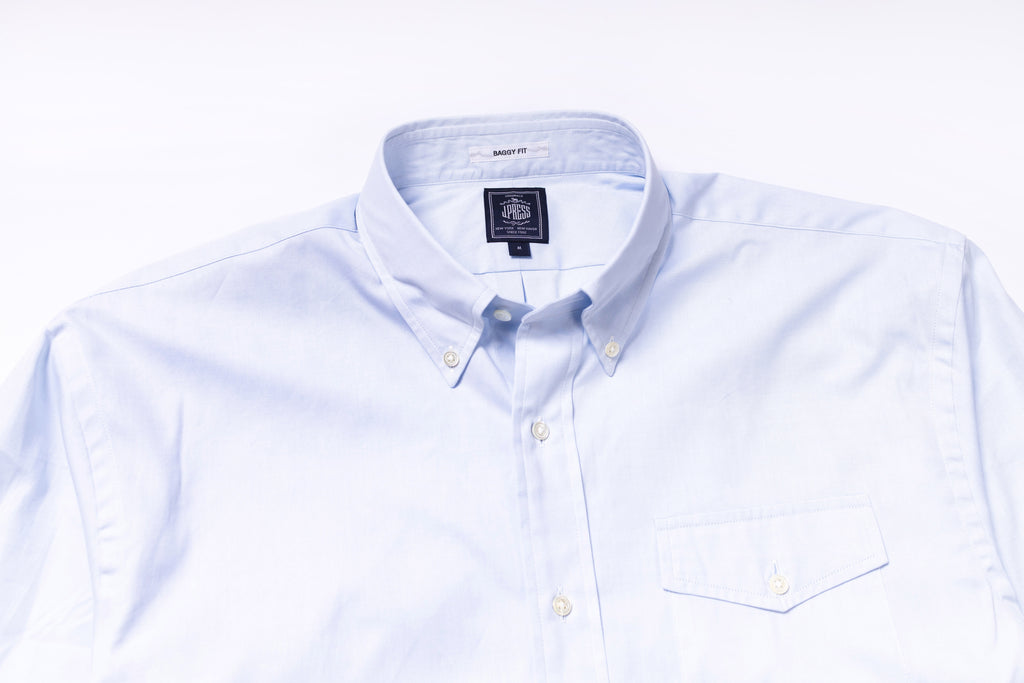 White dress shirt with collar and button details on a white background