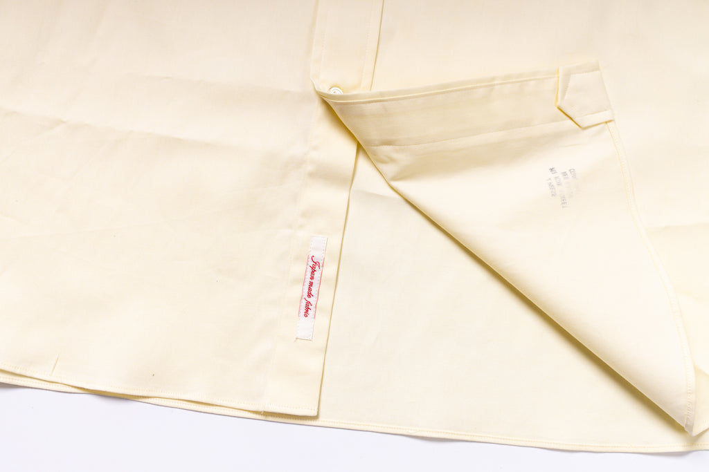 Close-up of a light-colored fabric with a tag on a white background