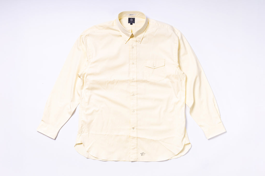 Light yellow button-up shirt on a white background