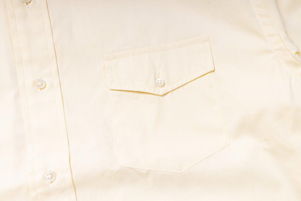 Close-up of a light-colored shirt with a pocket detail