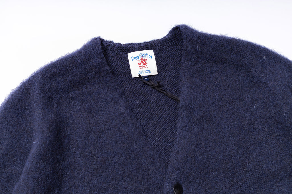 Navy blue cardigan with a brand label on a white background