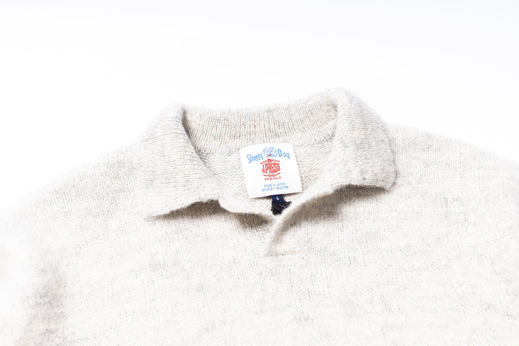 Close-up of a white fleece collar with a brand label on a white background