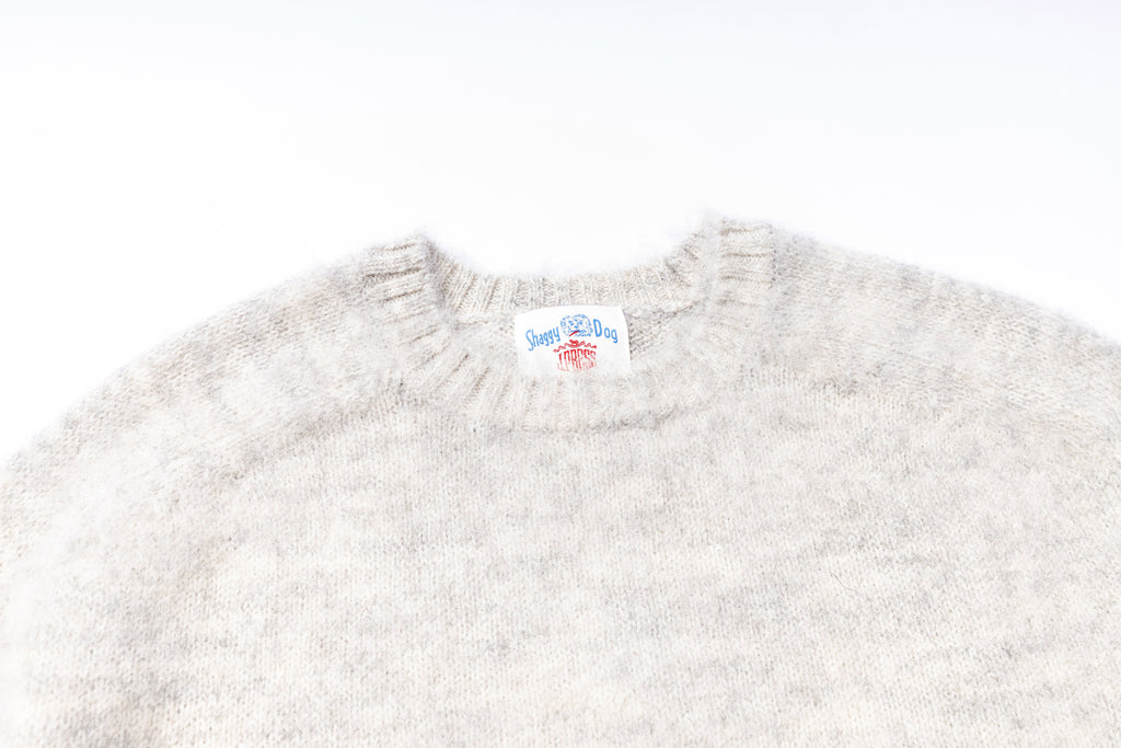 Gray sweater with a brand label on a white background