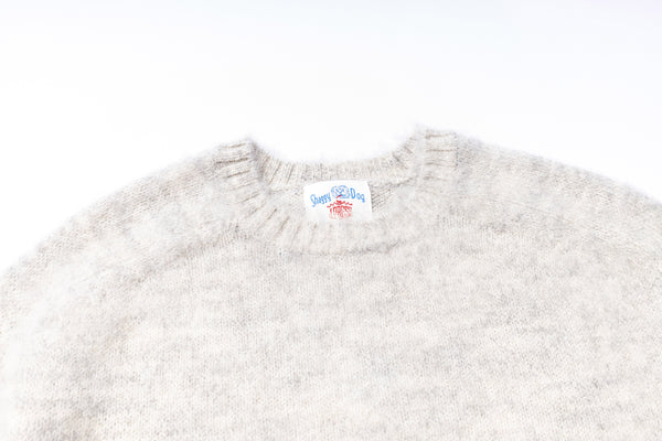 Gray sweater with a brand label on a white background