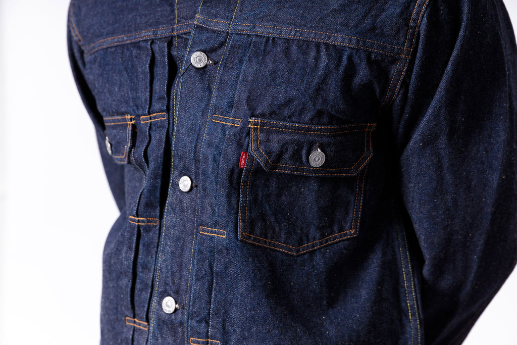 Close-up of a blue denim jacket with visible Levi's logo on a white background