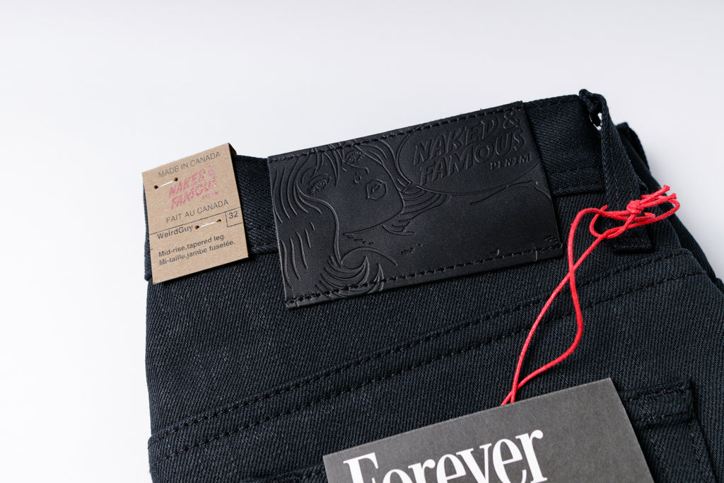 Black jeans with brand label on a white background