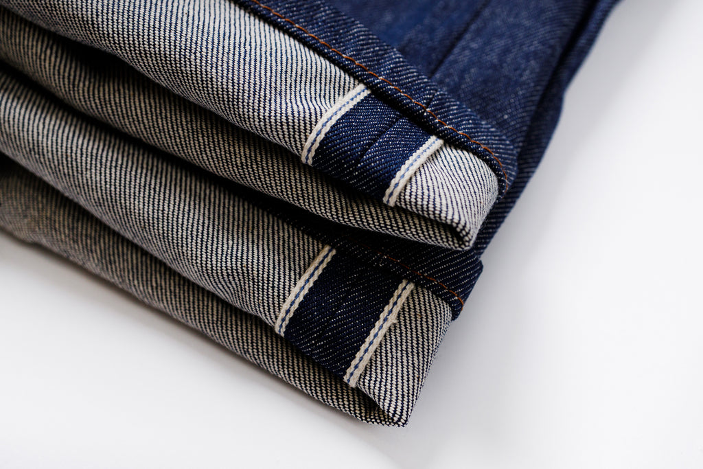 Folded denim jeans on a white background