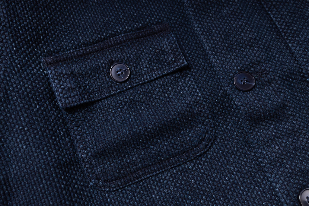 Close-up of a dark blue textured fabric with buttons