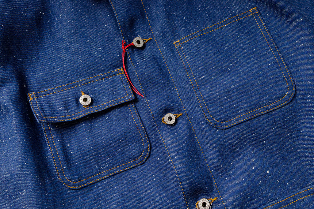 Close-up of a blue denim shirt with buttons and stitching details.