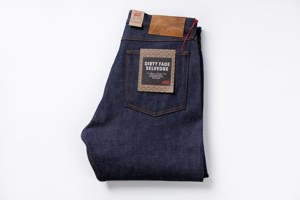 Folded pair of blue jeans with a brand label on a white background