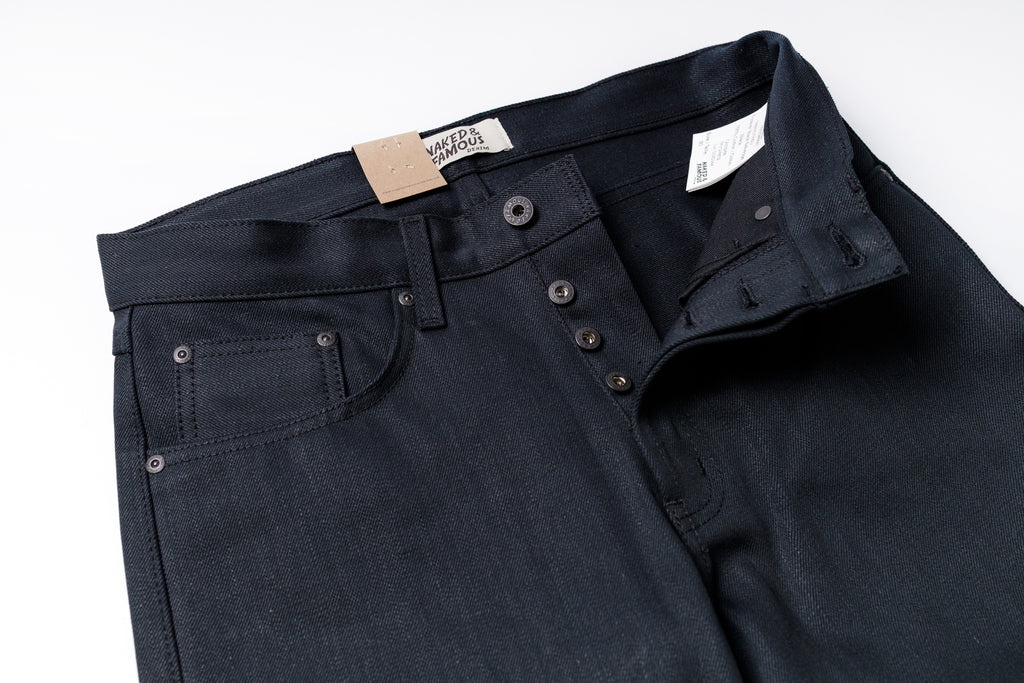 Dark blue jeans with a visible brand label on a white background