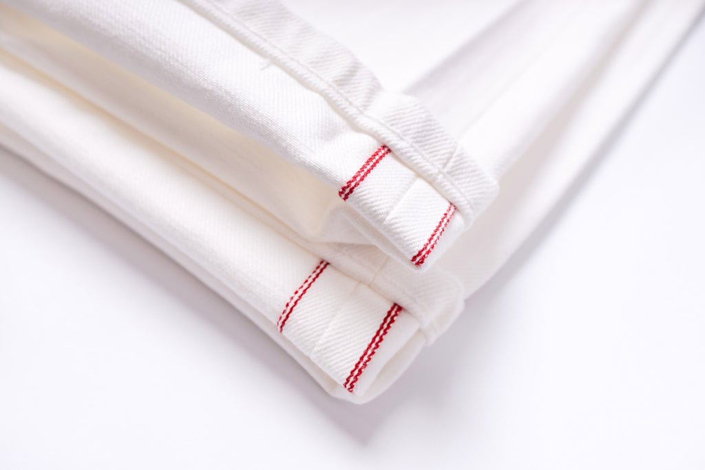 White fabric with red stitching on a white background