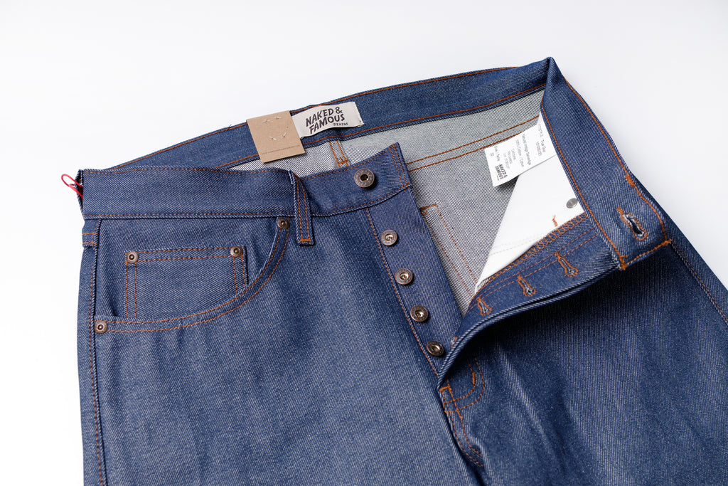 Blue jeans with visible brand labels on a white background