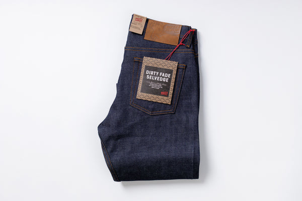 Folded pair of jeans with a visible brand label on a white background