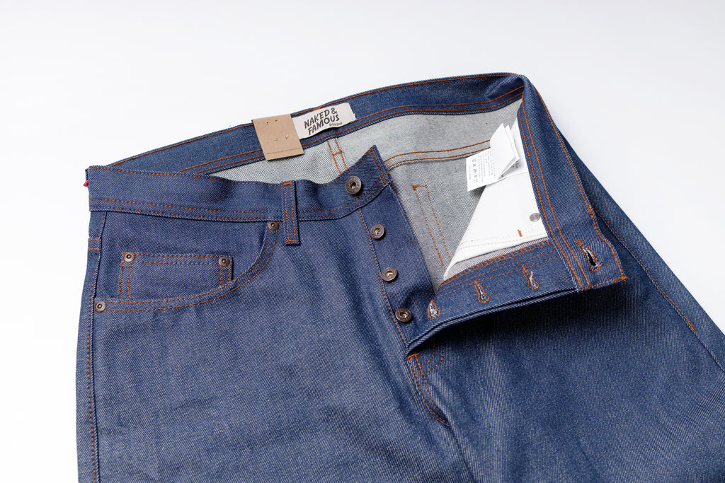 Blue denim jeans with a brand label on a white background