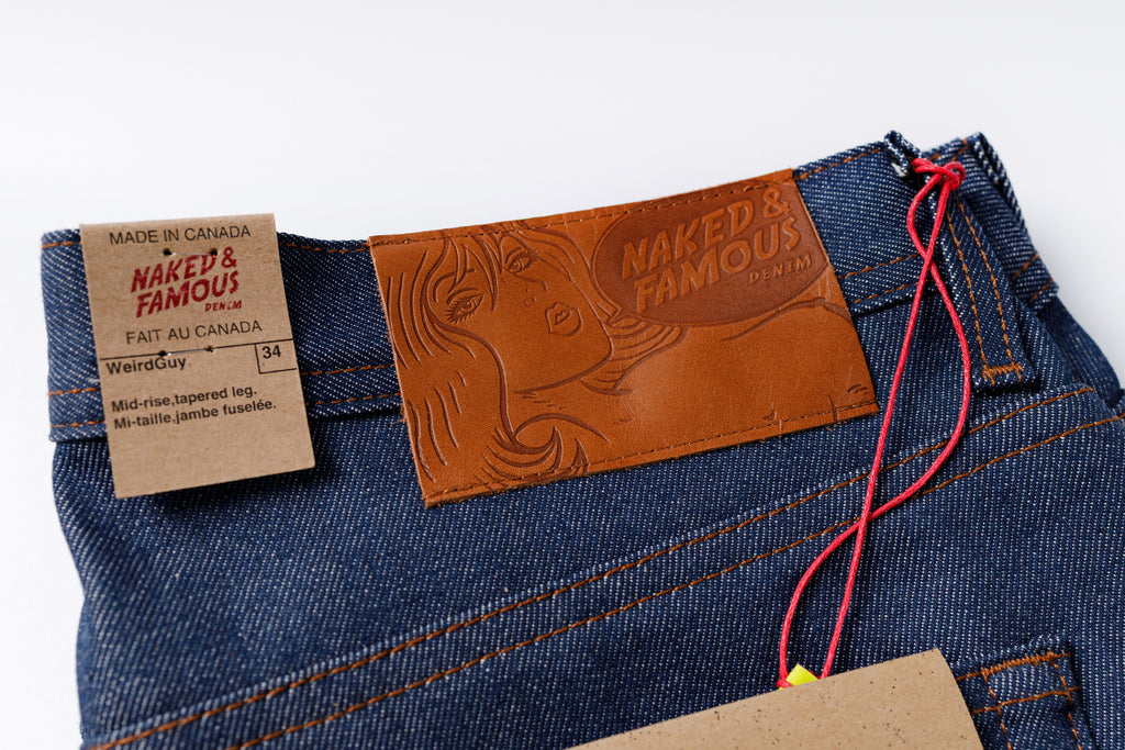 Naked & Famous jeans with brand label and tag on a white background