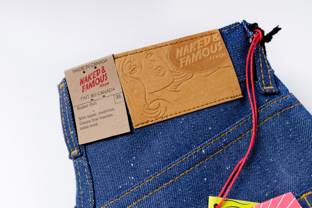 Close-up of blue jeans with a brand label on a white background