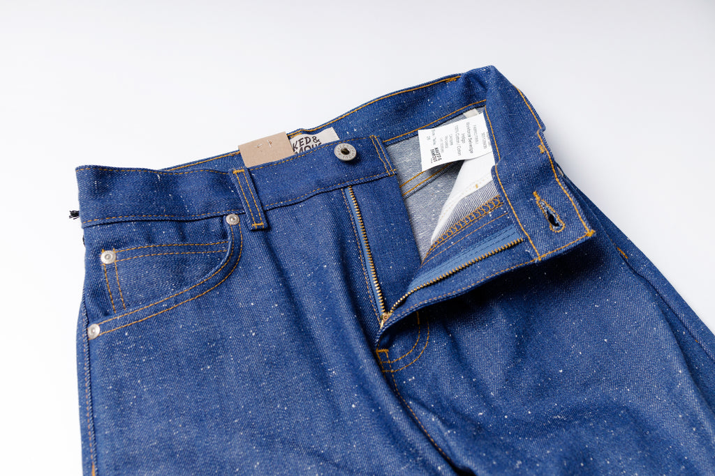 Blue jeans with a visible brand tag on a white background