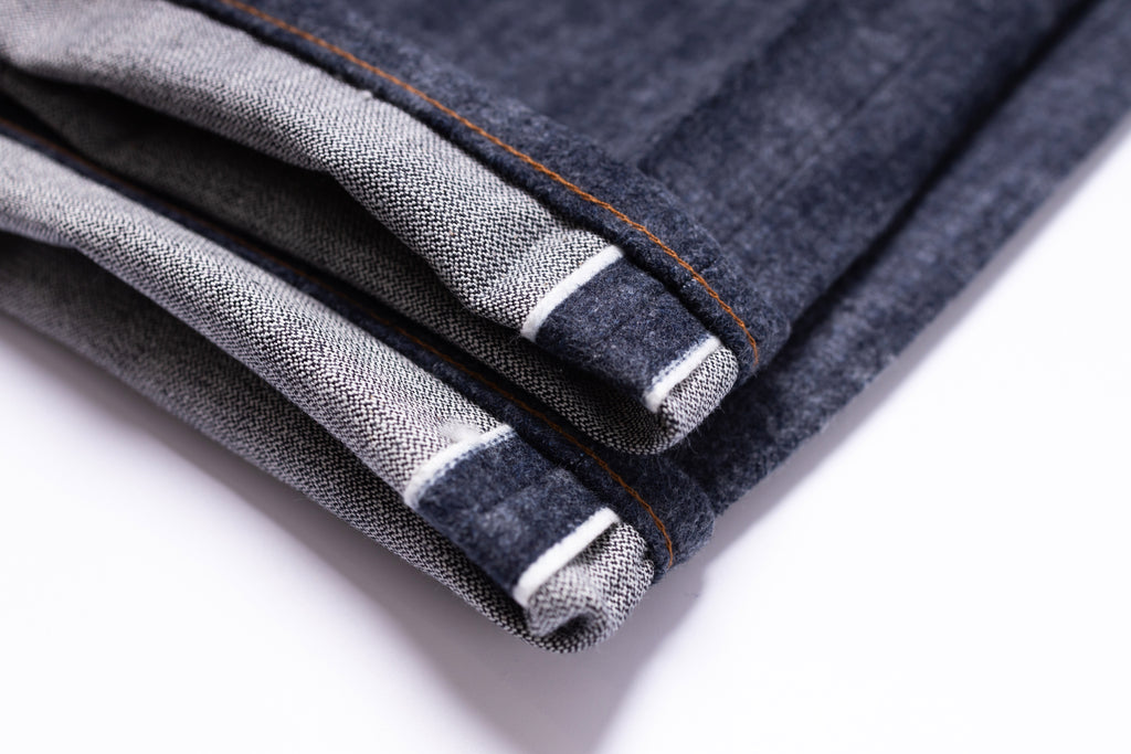 Close-up of folded denim fabric on a white background