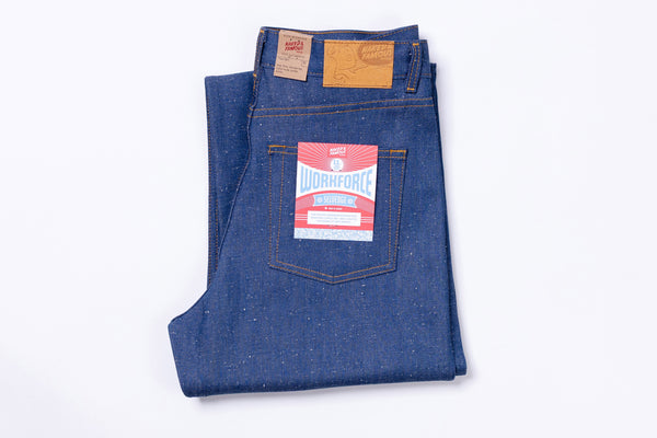 Folded blue jeans with a brand label on a white background