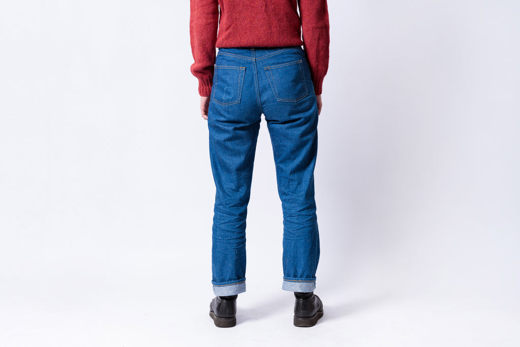 Person wearing blue jeans and a red sweater on a white background