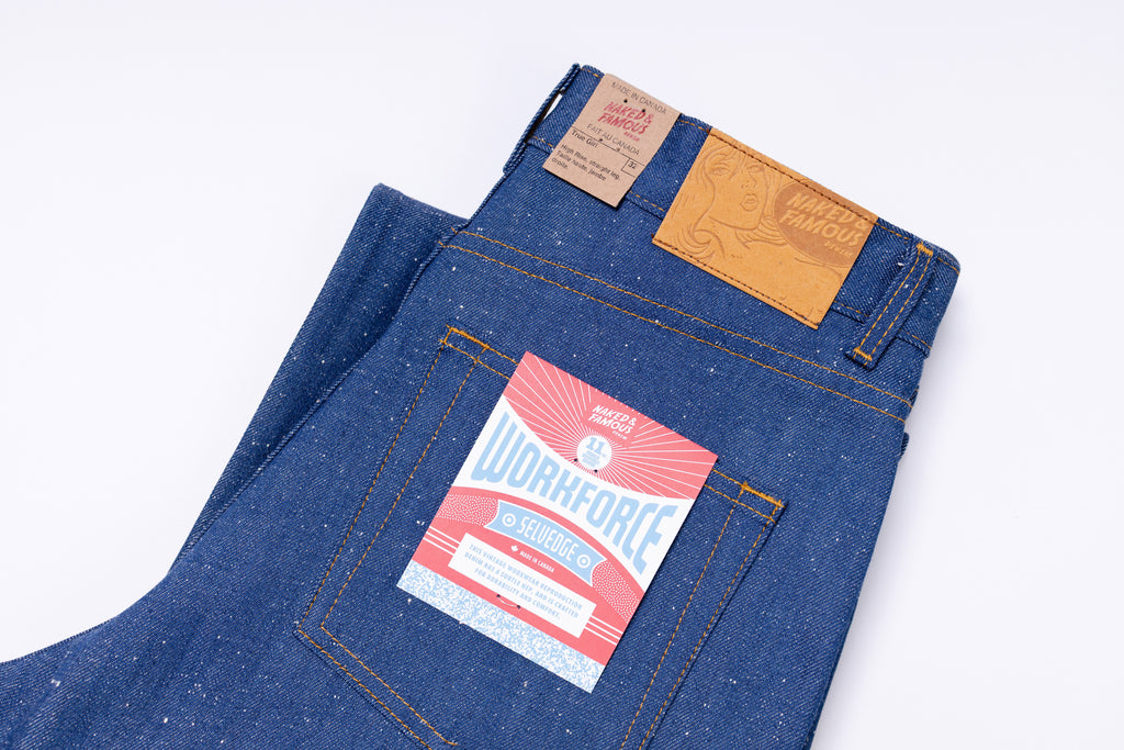 Folded blue denim jeans with a brand label on a white background