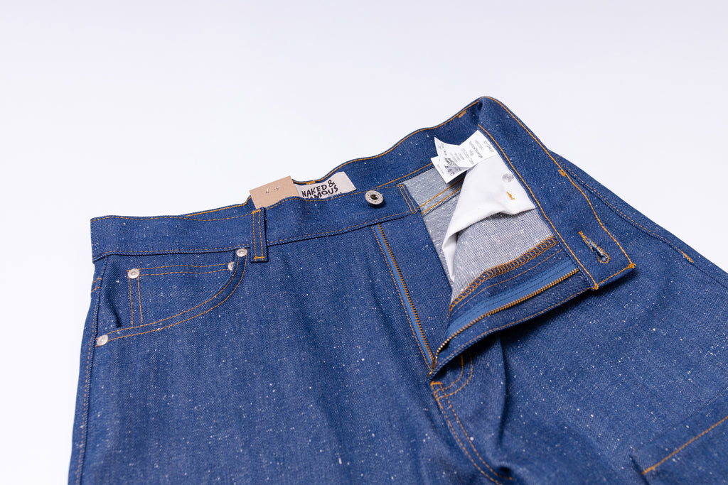 Blue denim jeans with a brand label on a light gray background