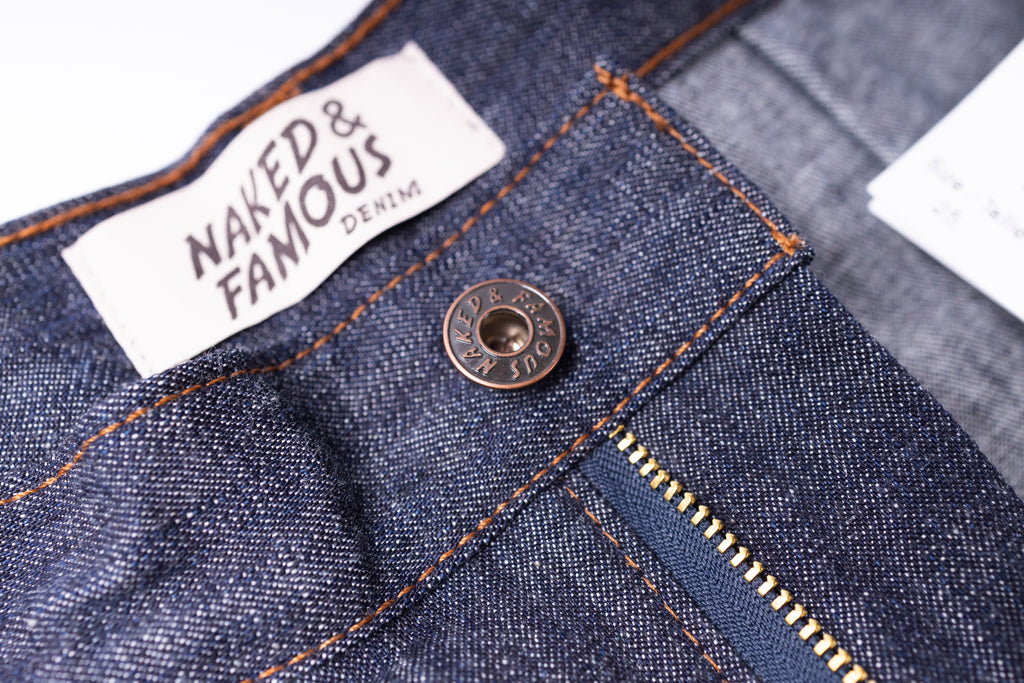 Close-up of a denim fabric with a 'Naked & Famous Denim' label.