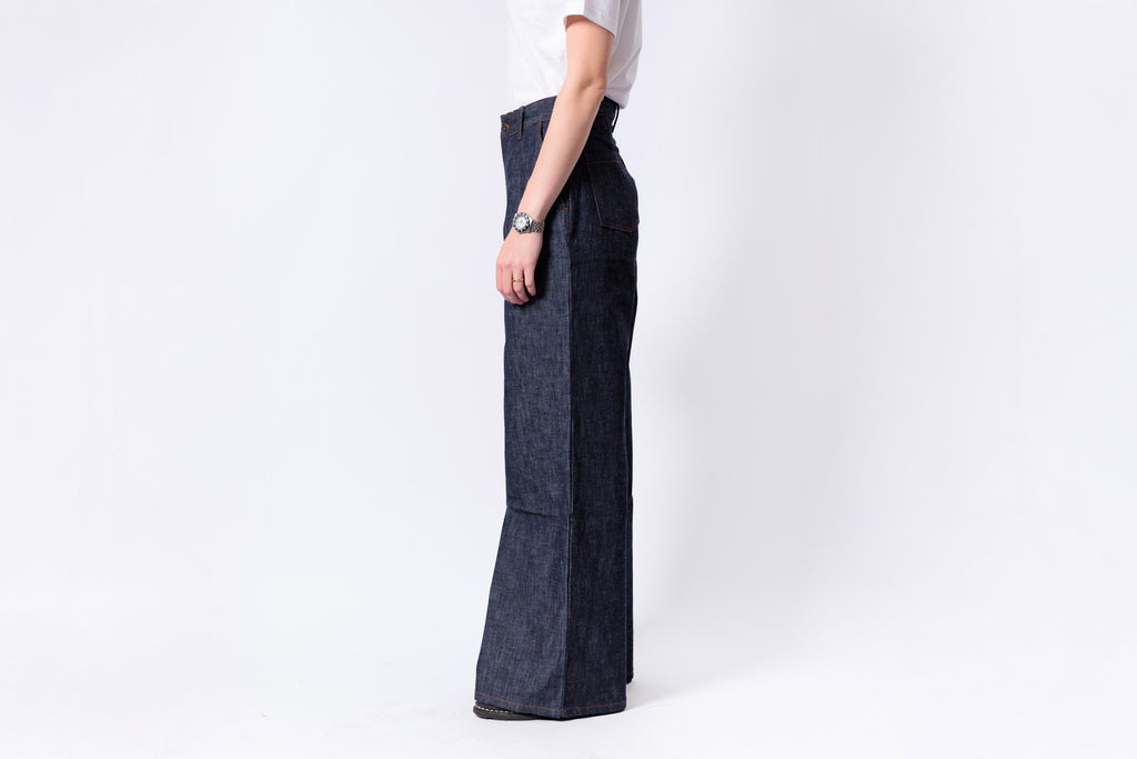 Person wearing dark denim wide-leg pants on a white background