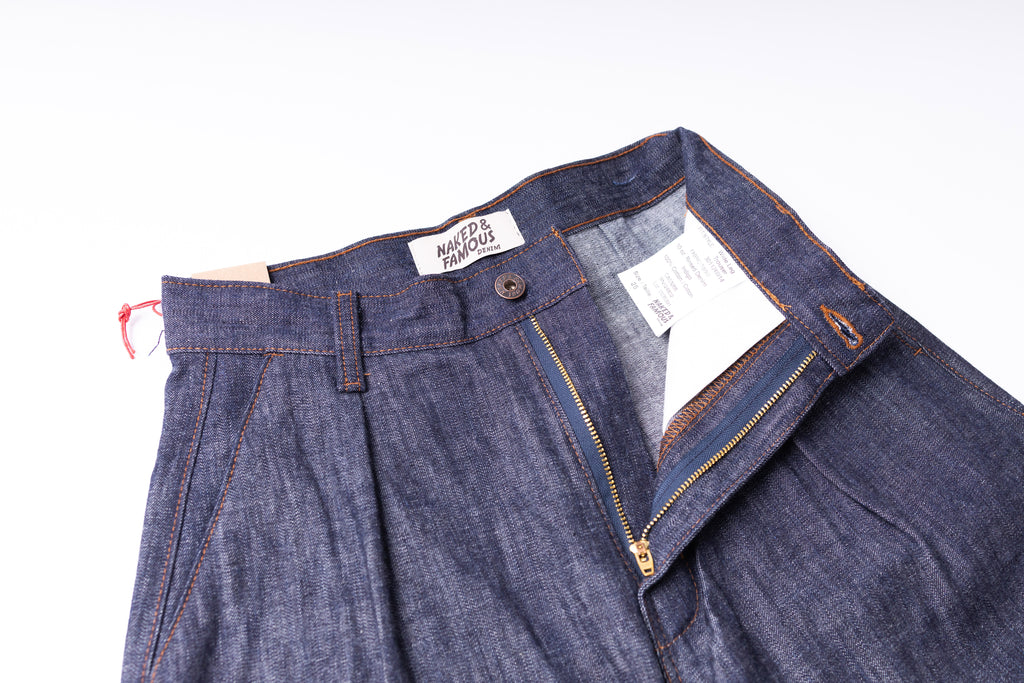 Blue denim pants with a brand label on a white background