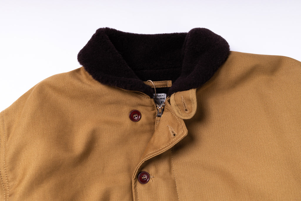 Close-up of a tan jacket with a black collar on a white background