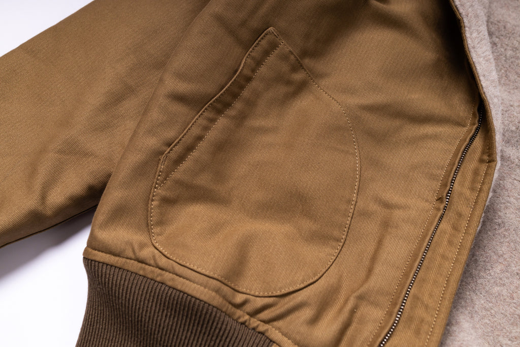 Close-up of a brown jacket with a pocket on a white background
