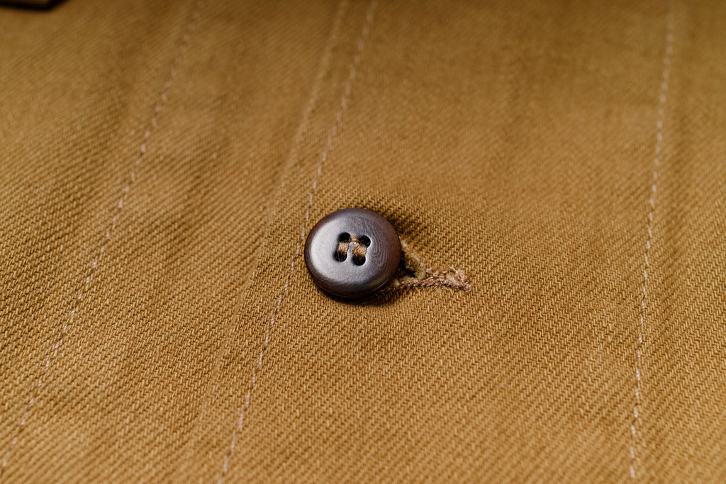 Close-up of a button on a brown fabric background