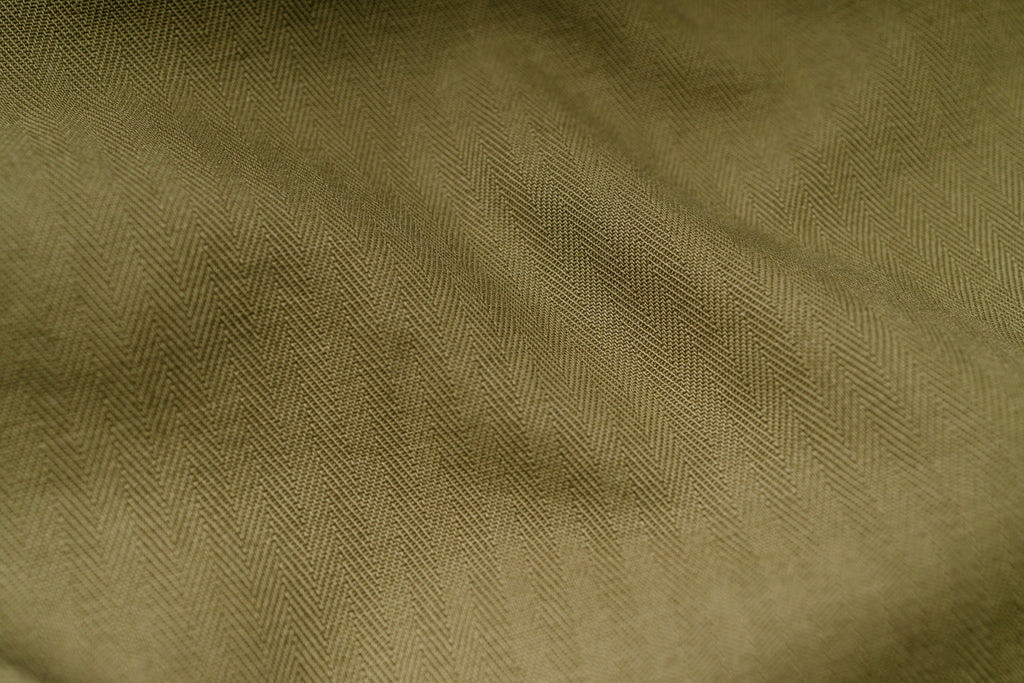 Close-up of olive green fabric with a subtle pattern