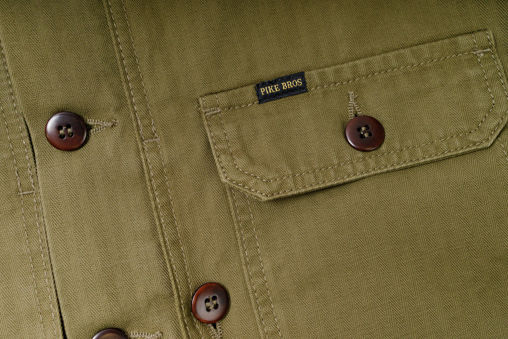 Close-up of a green jacket with buttons and a brand label.