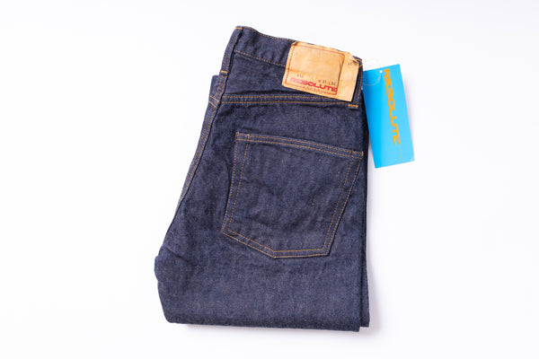Folded pair of blue jeans with a brand tag on a white background