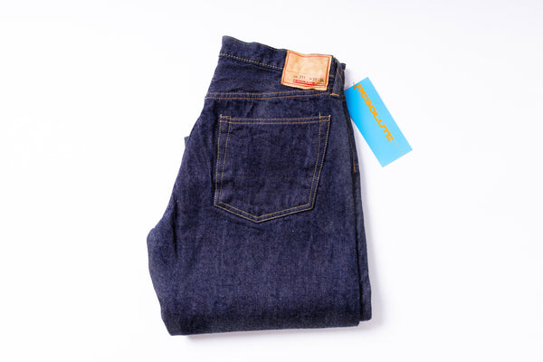 Folded pair of blue jeans with a tag on a white background