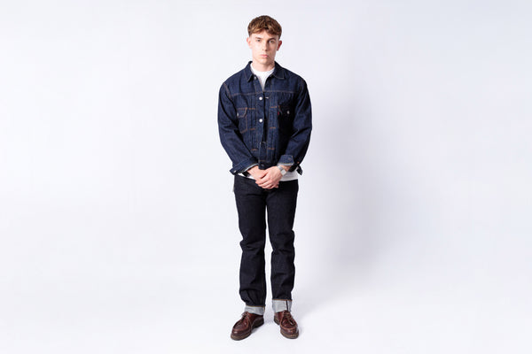 Man wearing a denim jacket and jeans on a white background