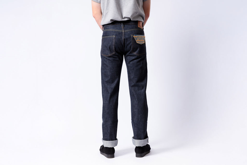 Person wearing dark blue jeans on a white background