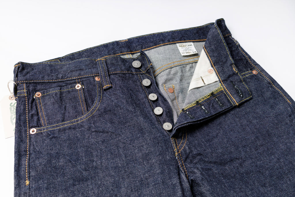 Close-up of a pair of blue jeans with a brand label on a white background