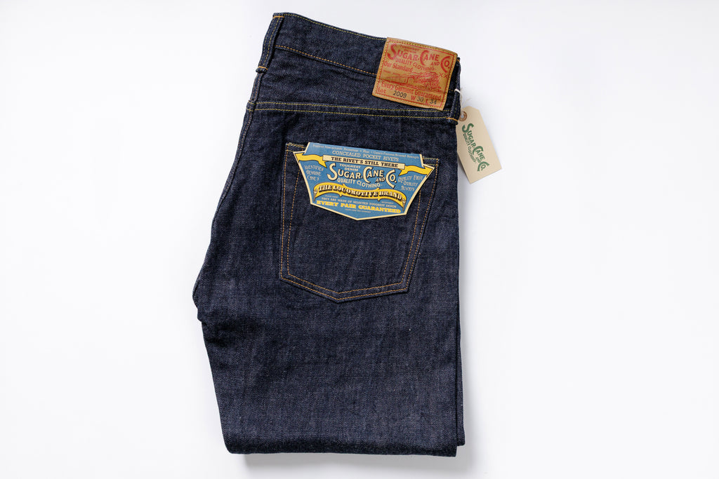 Folded pair of blue jeans with a brand label on a white background