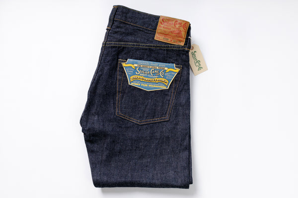 Folded pair of blue jeans with a brand label on a white background