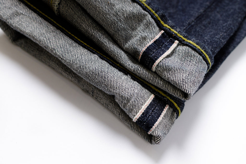 Folded denim jeans with a white background