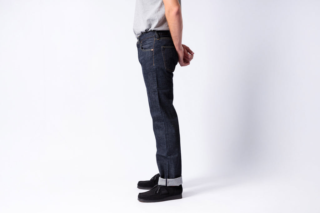 Person wearing dark blue jeans on a white background
